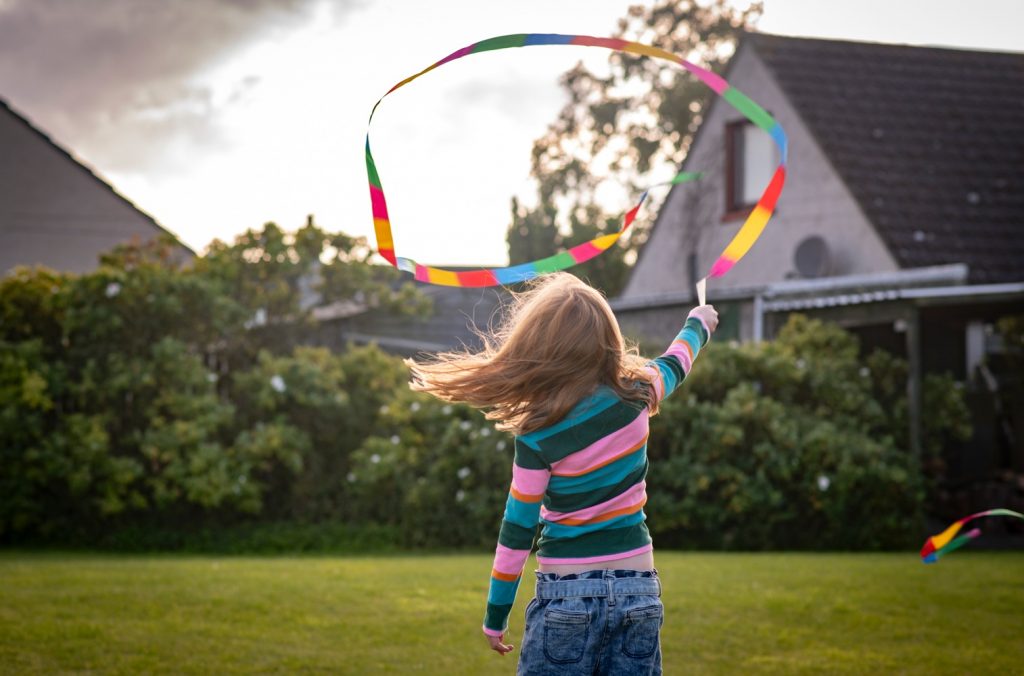 A young girl twirling a brightly coloured ribbon
